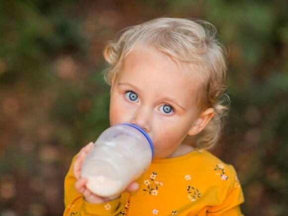 Baby girl drinking from her feeding bottle