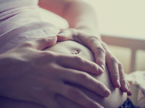 Twee handen op zwangere buik