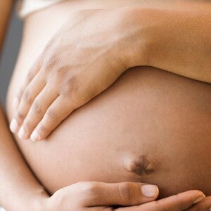 Zwangere vrouw houdt haar buik vast tijdens de laatste fase van de zwangerscha