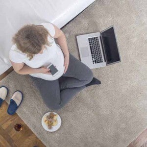 Zwangere vrouw met laptop en mobile