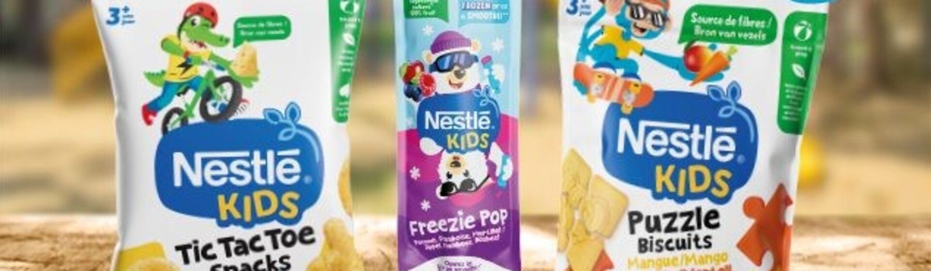 Nestlé Kids snacks op houten tafel, kleurrijke verpakkingen, speelse cartoons. Nieuw-label.