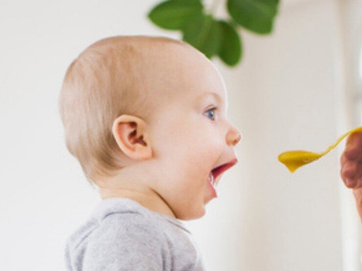 Mom feeding her baby with a spoon Mom feeding her baby with a spoon