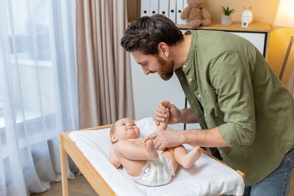 Vader verschoont lachende baby
